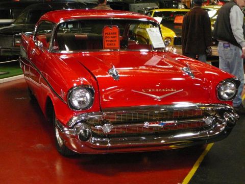 1997 Mercury Grand Marquis - A red 1957 Chevrolet Bel Air is displayed indoors, with other vehicles visible in the background.