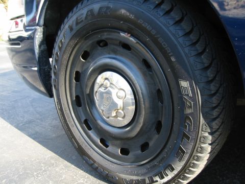 2003 Ford Crown Victoria - A close-up shot focuses on the wheel and tire of a Ford Crown Victoria, showing the brand and tire details.
