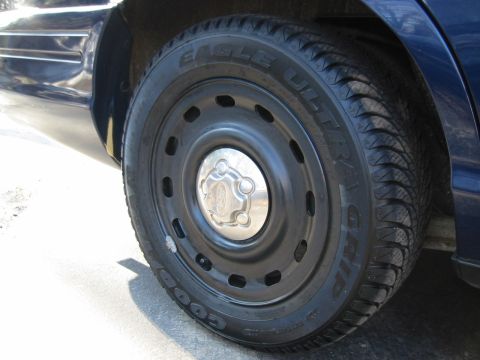 2003 Ford Crown Victoria - Close-up of a car's wheel and tire, showing the tread pattern and hubcap.