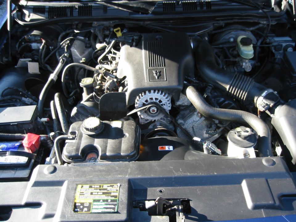 2003 Ford Crown Victoria engine bay showing V8 engine, air intake, battery, and coolant reservoir