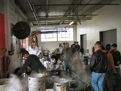 1985 Ford LTD Crown Victoria - A group of people are working in a steamy workshop environment with various brewing apparatus visible.