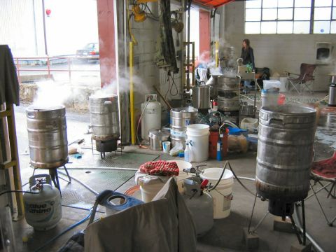 1985 Ford LTD Crown Victoria - Brewing equipment is set up and steaming inside a garage space.
