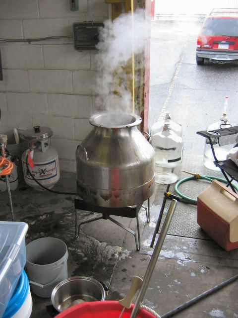 1985 Ford LTD Crown Victoria - A red SUV is parked outside a garage with a large steaming pot in the foreground.