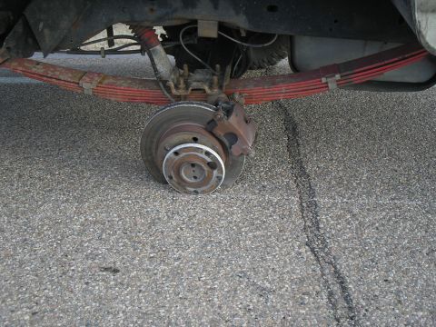 1990 Ford Bronco - Close-up view of a vehicle's rear suspension and brake system.