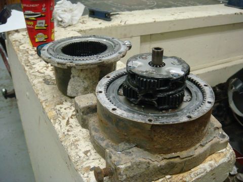 1996 Ford Bronco - A disassembled winch mechanism, showing gears and housing, rests on a workbench.