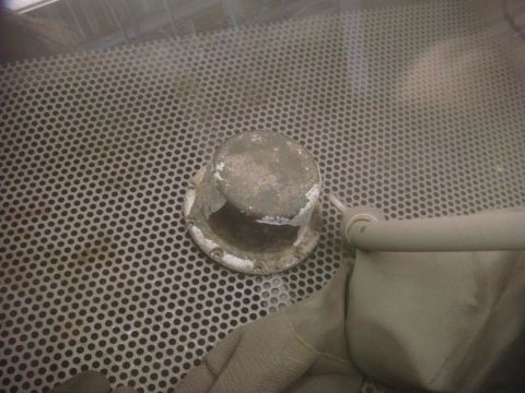 1996 Ford Bronco - A part sits on a perforated metal surface inside a sandblaster, with a gloved hand and hose visible.