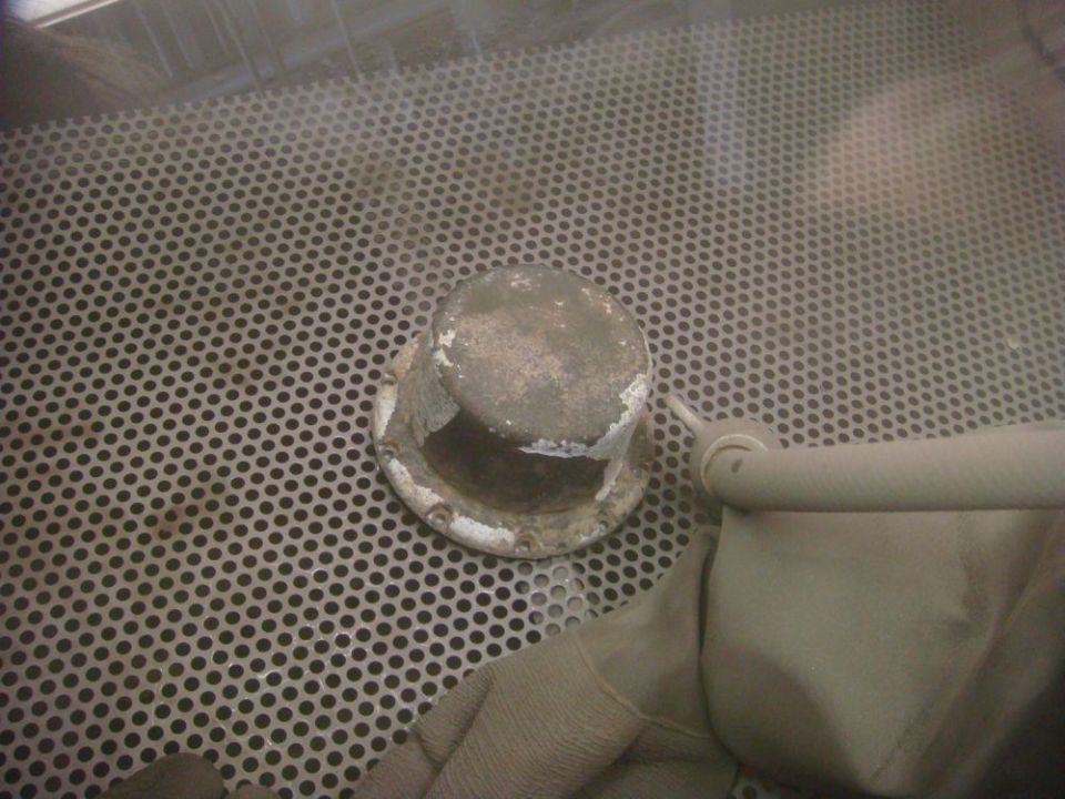 Part in sandblaster with glove and hose
