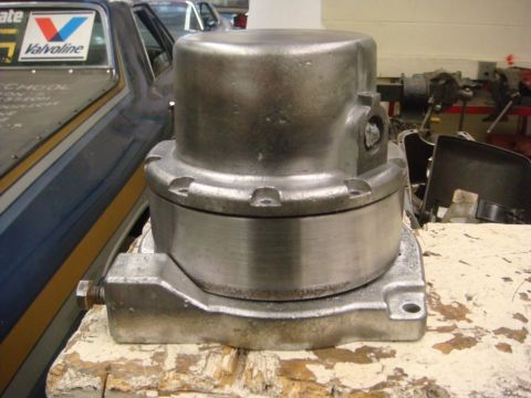 1996 Ford Bronco - A metal winch mechanism is displayed on a workbench, with a partially visible vehicle in the background.