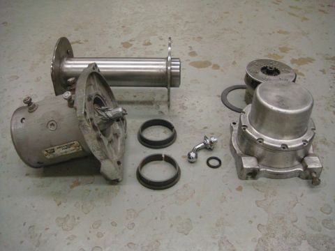 1996 Ford Bronco - Disassembled winch components are spread out on a concrete surface, showing various parts of the mechanism.