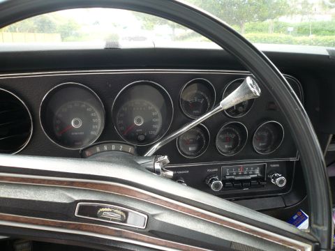 1975 Ford Ranchero - The interior of a classic car features a dashboard with multiple gauges and a vintage radio.