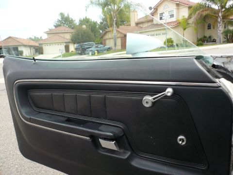 1975 Ford Ranchero - The interior door panel of a 1975 Ford Ranchero features black upholstery and a chrome window crank.