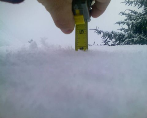 1978 Ford Bronco - Measuring snow depth with a tape measure in a snowy environment.