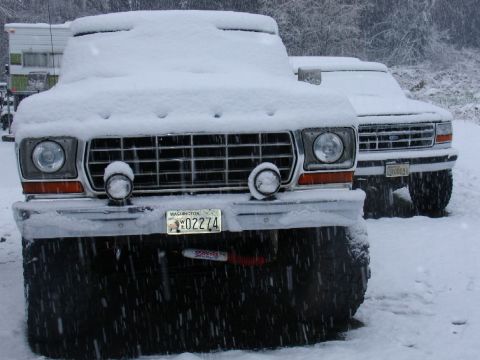 1978 Ford Bronco - Two trucks sit covered in snow, with one prominently displaying a Washington license plate.