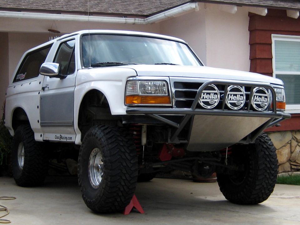 White Ford Bronco prerunner with tube bumper and Hella lights, 3q-front