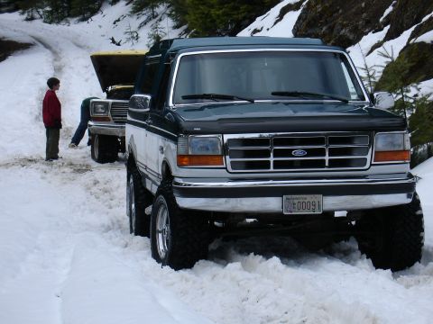 1978 Ford Bronco - A two-tone Ford Bronco is stuck in the snow, with another vehicle in the background also appearing to be stuck.