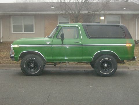 1979 Ford Bronco - Side view of a green 1979 Ford Bronco with a black hardtop.