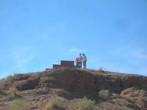 1985 Ford Bronco - A family poses for a photo on a hill with a wooden structure in the background.