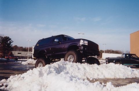 1994 Ford Bronco - Lifted 1994 Ford Bronco navigating a snowy parking lot.