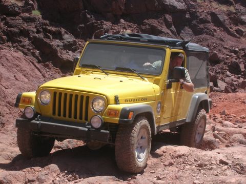 1985 Ford Bronco - A yellow Jeep Wrangler Rubicon navigates a , rocky landscape, highlighting its off-road capabilities.