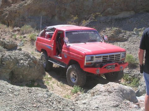 1985 Ford Bronco - This 1985 Ford Bronco is shown off-roading on a , rocky trail in a desert-like environment.