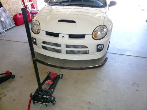 1996 Ford Probe - White Dodge Neon SRT-4 with a floor jack positioned in front of its bumper.