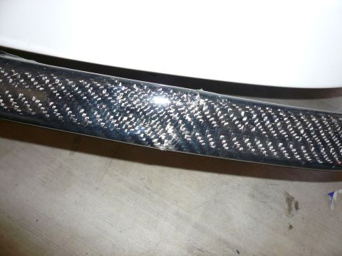 1996 Ford Probe - A close-up view of a damaged carbon fiber trim piece.