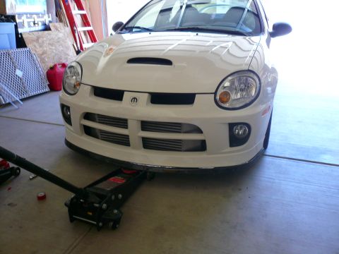 1996 Ford Probe - White Dodge Neon SRT-4 front end with intercoolers visible, being worked on with a floor jack.