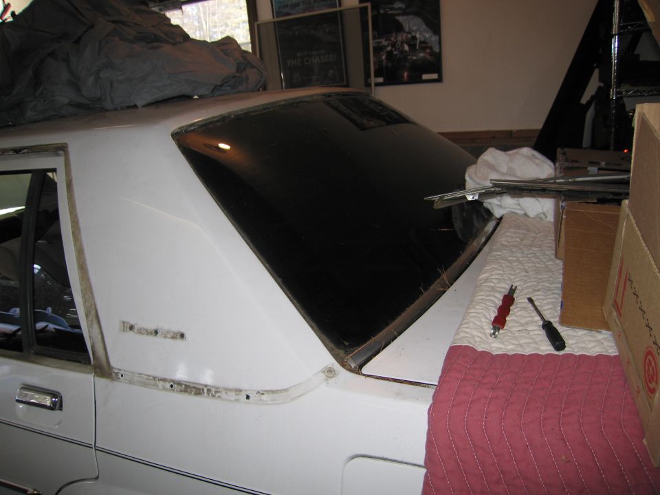 1991 Ford Crown Victoria LTD rear window trim being removed, car is white