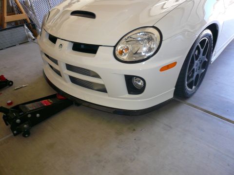 1996 Ford Probe - The front of a white Dodge Neon SRT-4 is shown with a floor jack positioned underneath the front bumper.
