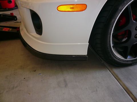 1996 Ford Probe - Close-up of a white sports car's front corner, showing the bumper, wheel, and tire.