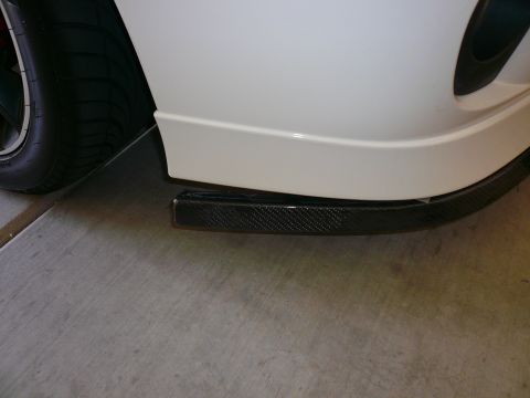 1996 Ford Probe - Close-up of a carbon fiber front splitter installed on a vehicle's bumper.