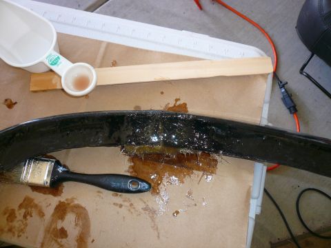 1996 Ford Probe - A close-up shows a black automotive part being repaired with adhesive and a brush.