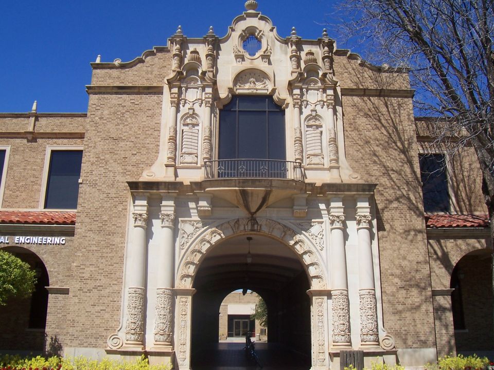 Building entrance with ornate stonework and an arched walkway, text reads "AL ENGINEERING"