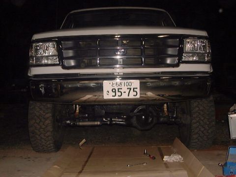 1994 Ford Bronco - Front view of a white Ford Bronco with a chrome grille and large tires, displaying a Japanese license plate.