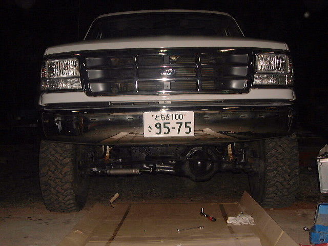 White Ford Bronco front view, chrome grille, large tires, Japanese license plate