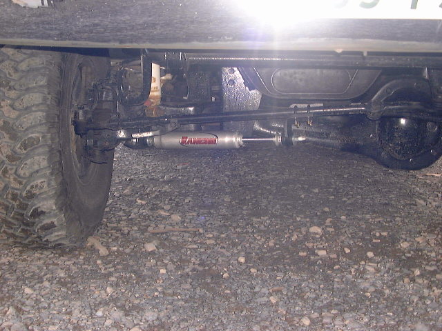 Steering stabilizer with 'Rancho' text on vehicle's front axle