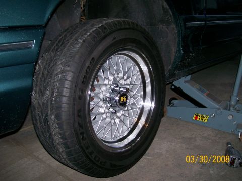1995 Mercury Grand Marquis - Close-up of a vehicle's wheel and tire, with a jack supporting the car.