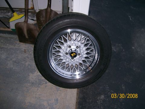 1995 Mercury Grand Marquis - Aftermarket wire-spoke wheel and tire assembly, likely for a car.