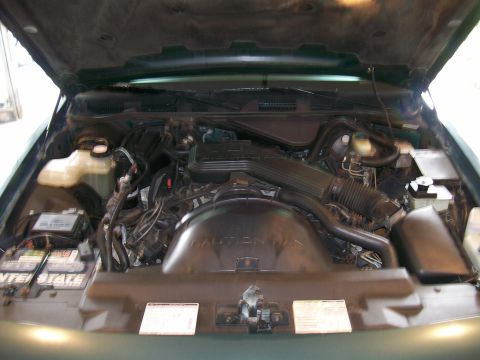 1995 Mercury Grand Marquis - Engine bay of a vehicle, showing the air intake system and battery. Text on fan shroud is visible.