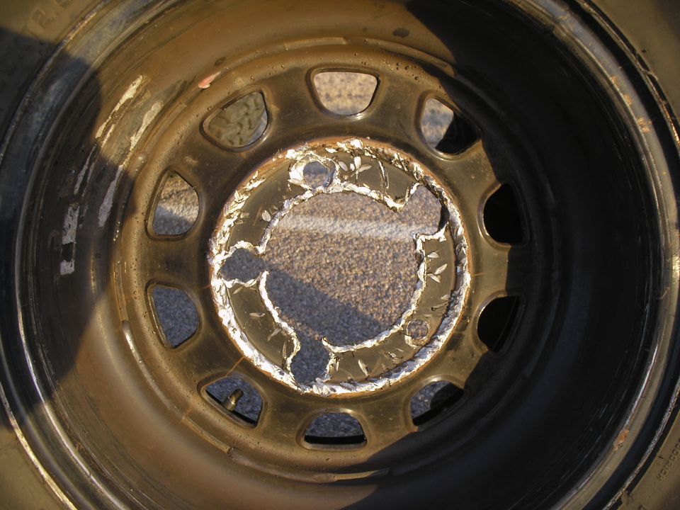 Damaged wheel rim with peeling paint and rust