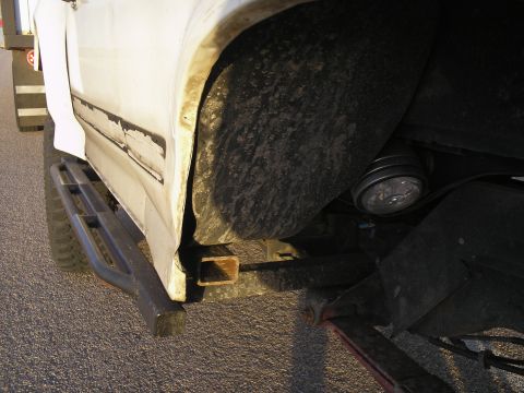 1990 Ford Bronco - The photo shows the lower side panel and wheel well of a vehicle, with a visible Supermotors watermark.