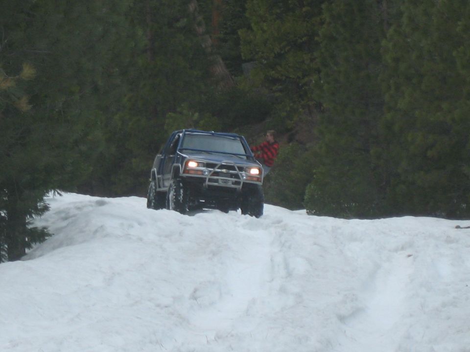 Dark blue 1995 Ford Bronco with aftermarket bumper driving in snow