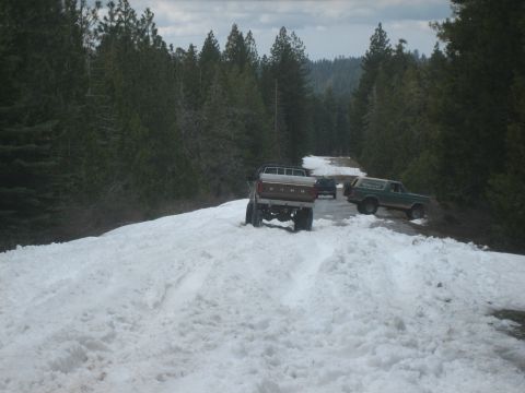1995 Ford Bronco - A 1995 Ford Bronco navigates a snow-covered road alongside other vehicles.