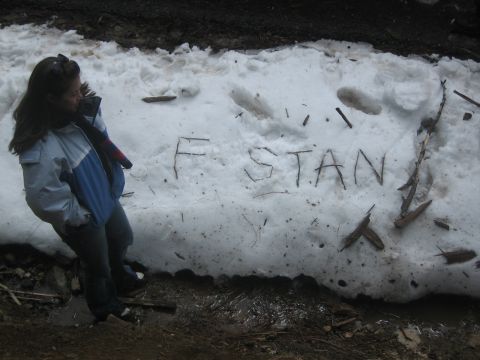 1995 Ford Bronco - A person stands next to a snowbank where 'F STAN' has been written with sticks.