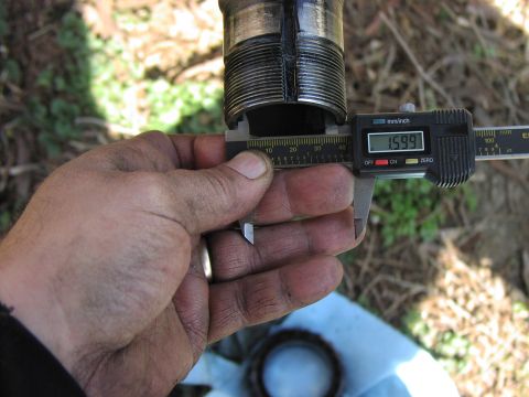 1986 Ford Bronco - Digital calipers measure a threaded metal part at 1.599 inches, with a Supermotors.net logo visible.