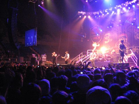 1988 Ford Bronco - A band performs on stage for a large crowd at a concert, illuminated by stage lighting.