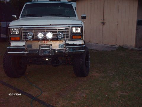 1982 Ford F-100 - This 1980s Ford truck features a custom bumper with a winch and additional lighting, suggesting off-road modifications.
