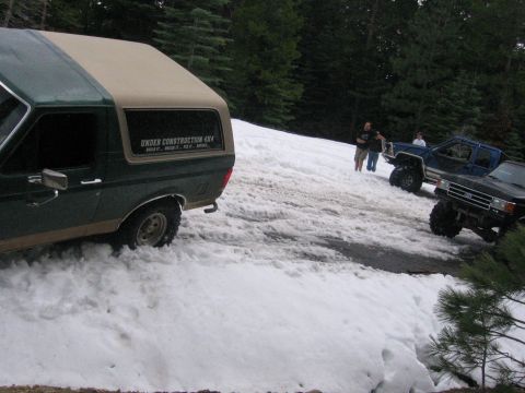 1989 Ford Bronco - 1989 Ford Bronco navigating a snowy road with other off-road vehicles.