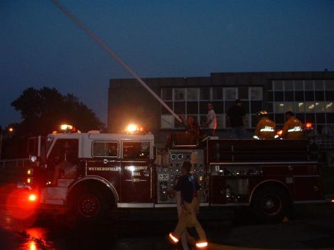 1990 Ford Bronco - A fire truck is shown at dusk with its lights flashing and a water stream being sprayed.