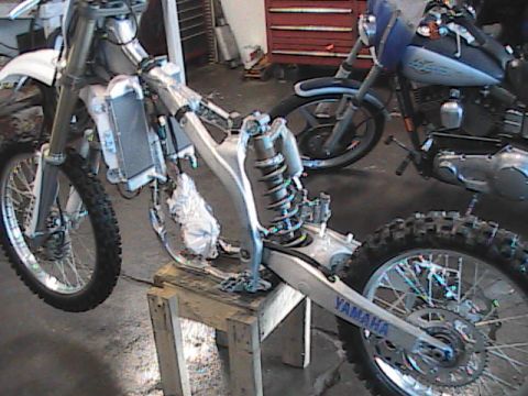 2007 Yamaha YZ450F - A disassembled motorcycle frame is shown, with another motorcycle partially visible in the background.